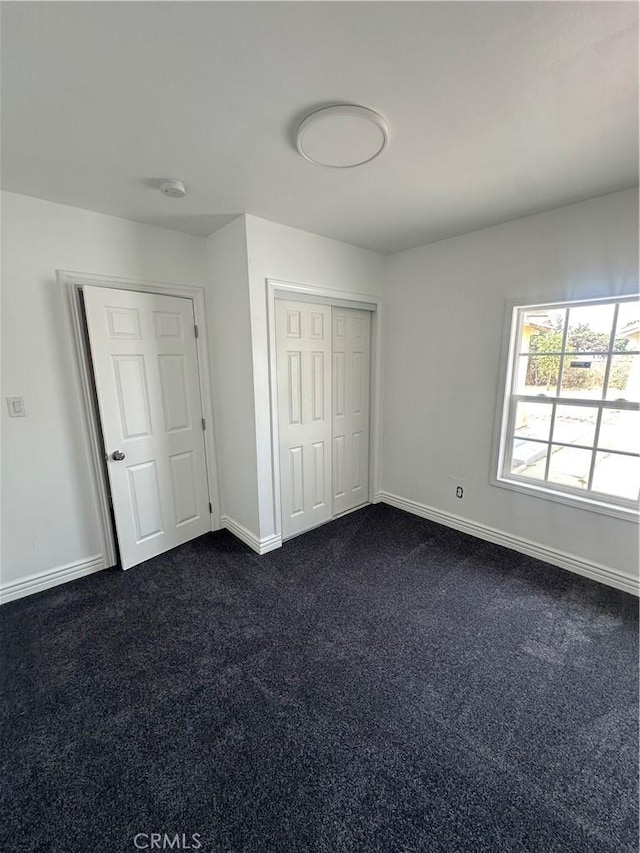 unfurnished bedroom with dark carpet