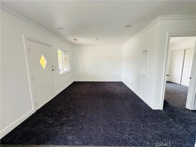 spare room featuring dark colored carpet and ornamental molding