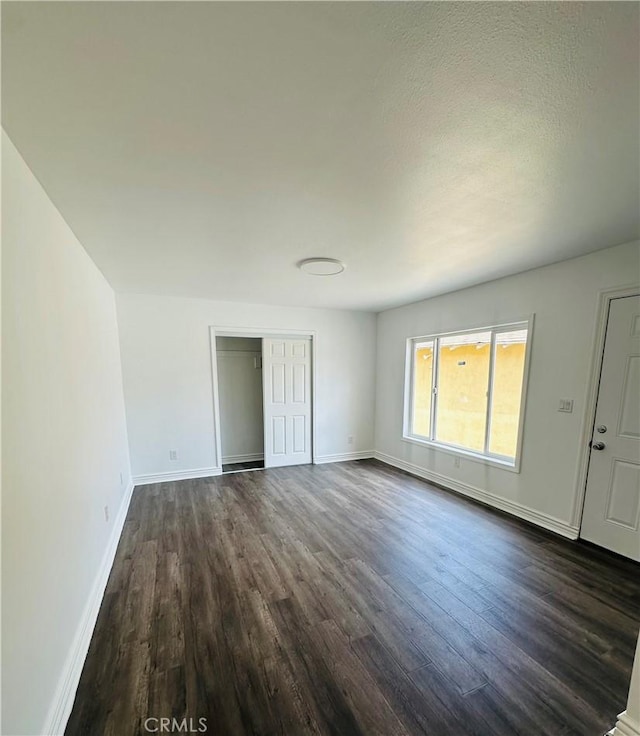 interior space with a textured ceiling and dark wood-type flooring