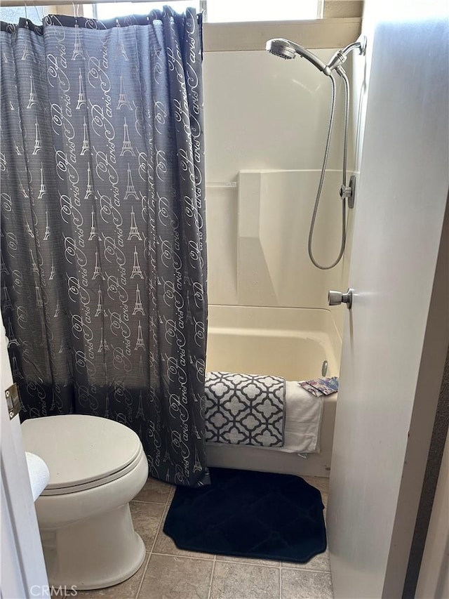 bathroom with tile patterned floors, shower / bath combination with curtain, and toilet