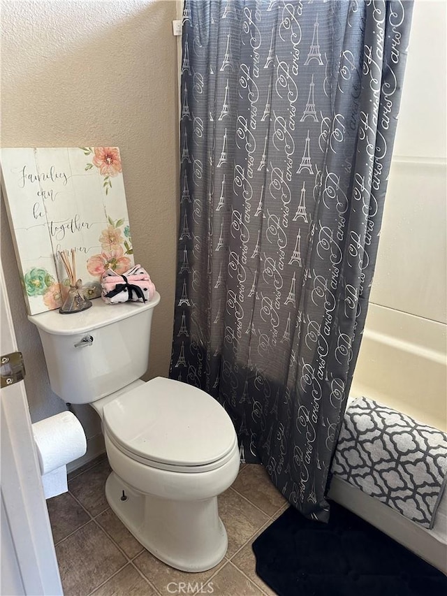 bathroom featuring tile patterned floors, shower / tub combo with curtain, and toilet