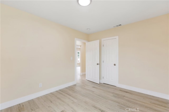 unfurnished bedroom with light hardwood / wood-style flooring and a closet