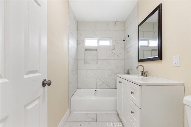 full bathroom featuring tiled shower / bath, vanity, toilet, and a healthy amount of sunlight