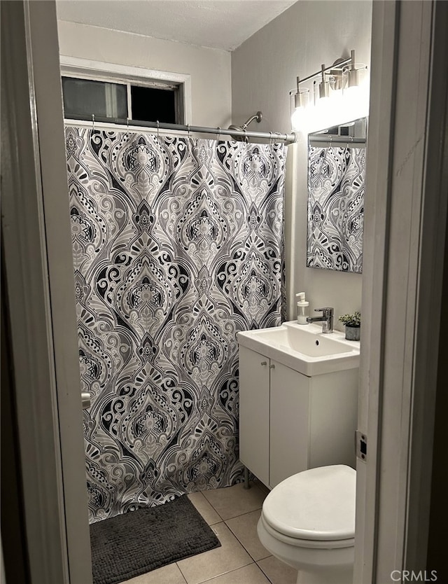 bathroom with tile patterned floors, walk in shower, vanity, and toilet