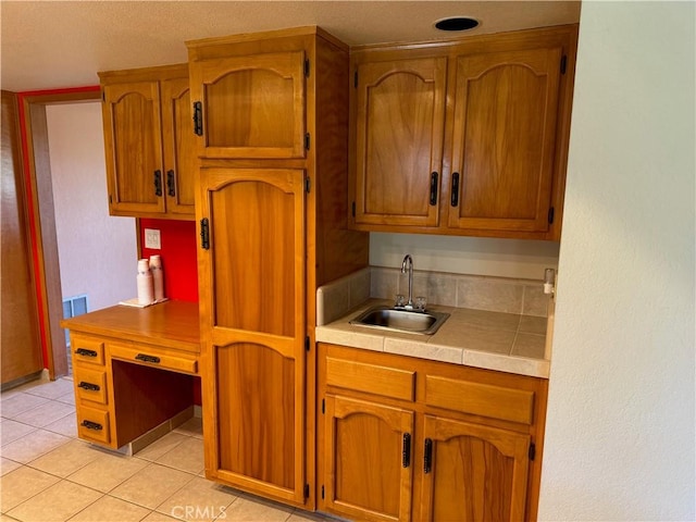 kitchen featuring light tile patterned floors and sink