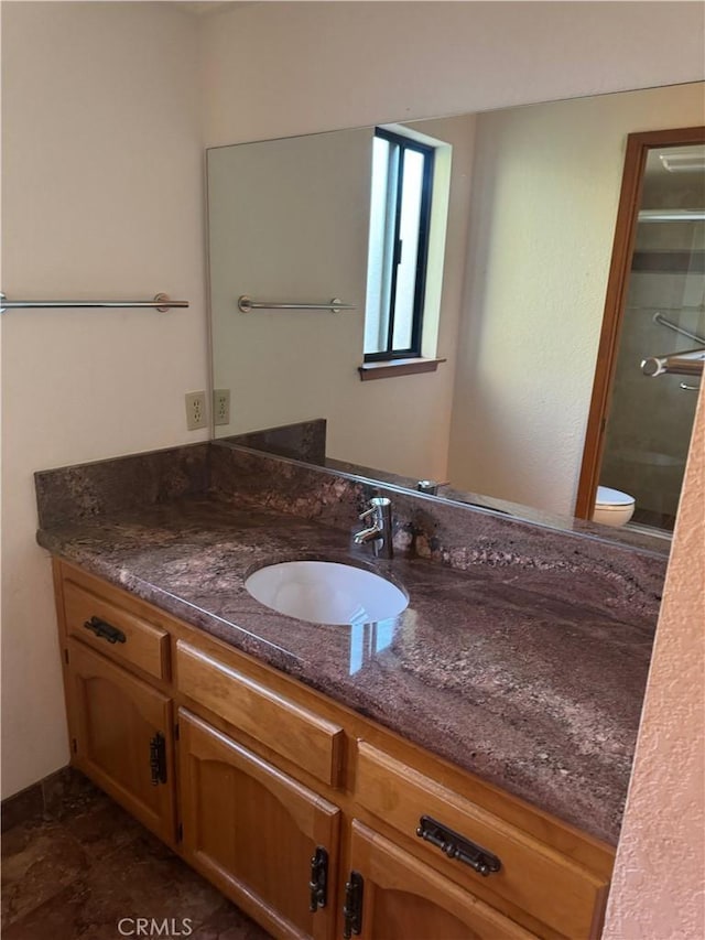 bathroom featuring vanity, toilet, and a shower