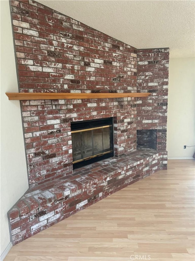 room details featuring a fireplace, a textured ceiling, and hardwood / wood-style flooring