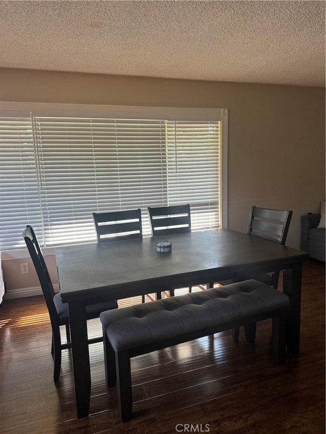 dining area with dark hardwood / wood-style floors and a textured ceiling