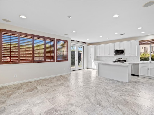 kitchen with white cabinets, appliances with stainless steel finishes, and a center island