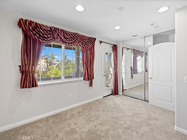 unfurnished bedroom with light carpet and a closet