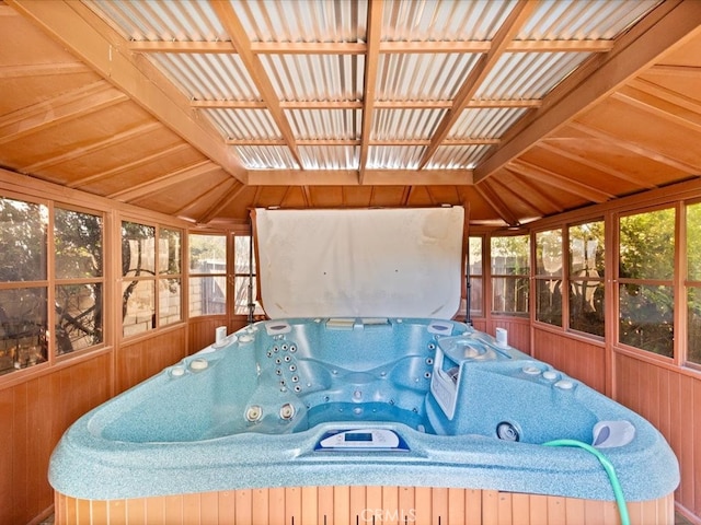 sunroom / solarium featuring lofted ceiling, a hot tub, and a wealth of natural light