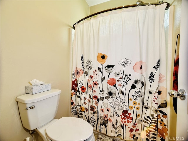 bathroom with toilet and a shower with shower curtain