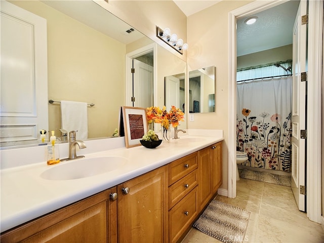 bathroom featuring curtained shower, vanity, and toilet