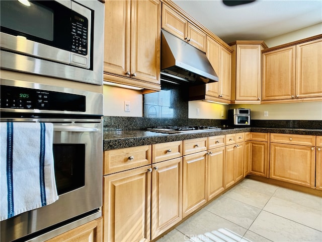 kitchen with appliances with stainless steel finishes and light tile patterned floors