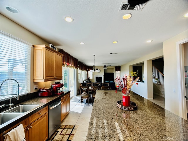 kitchen with dishwasher, decorative light fixtures, sink, and light tile patterned flooring