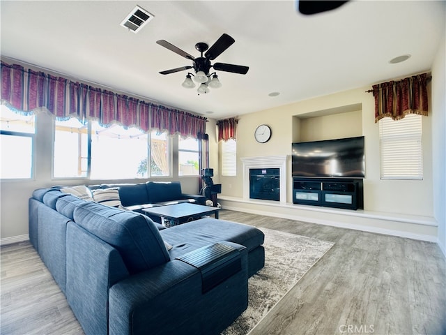 living room with light hardwood / wood-style floors and ceiling fan