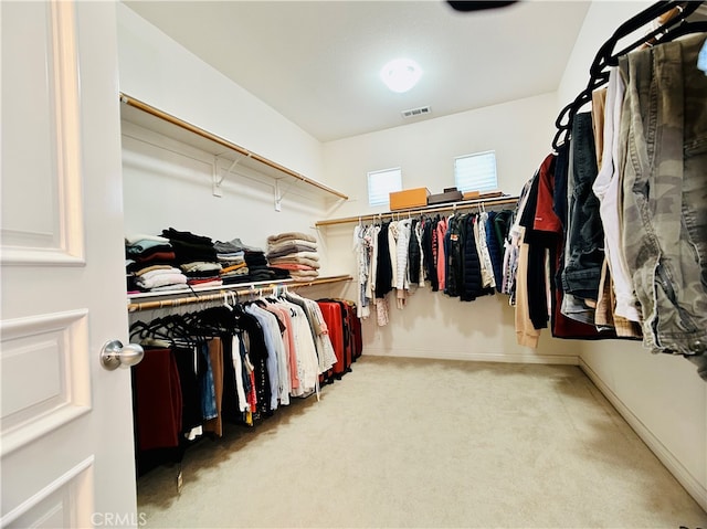 walk in closet with light colored carpet