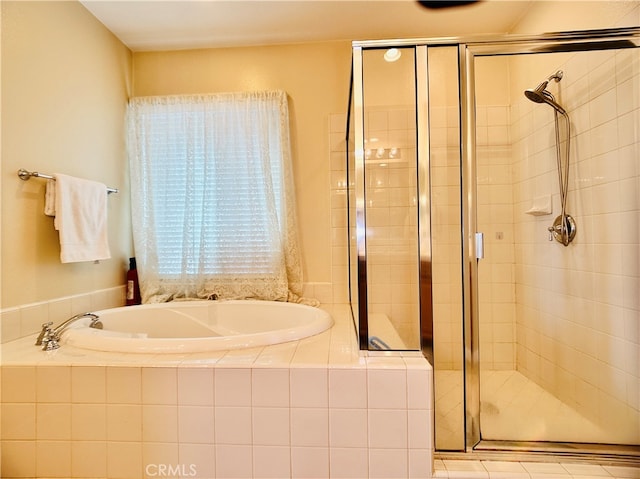 bathroom with shower with separate bathtub and tile patterned floors