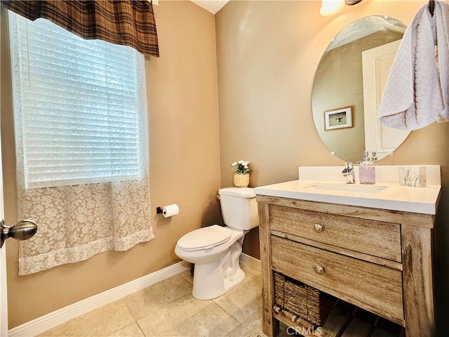 bathroom with a healthy amount of sunlight, tile patterned flooring, vanity, and toilet