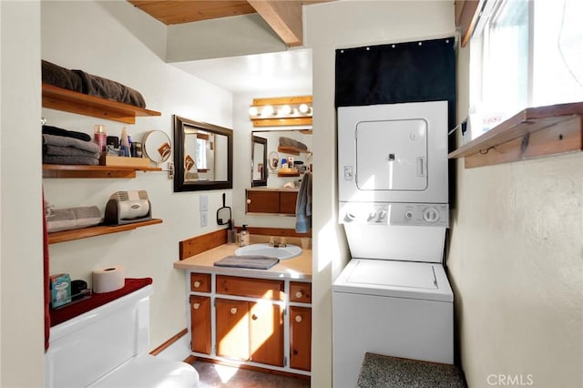 laundry area featuring laundry area, stacked washing maching and dryer, and a sink
