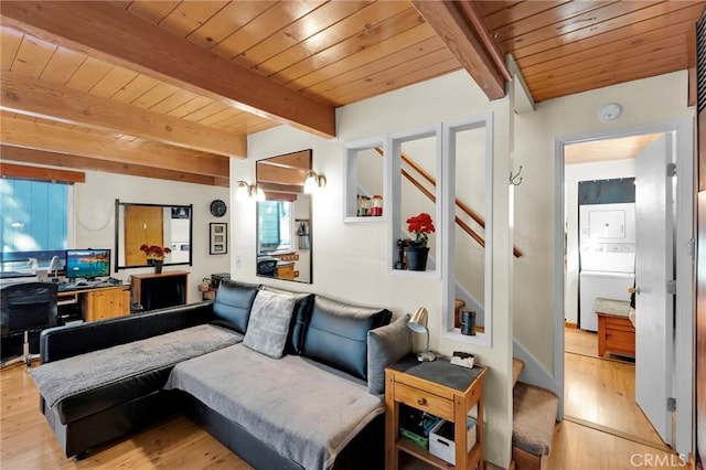 living area with light wood-style floors, stacked washer and dryer, beam ceiling, and wooden ceiling