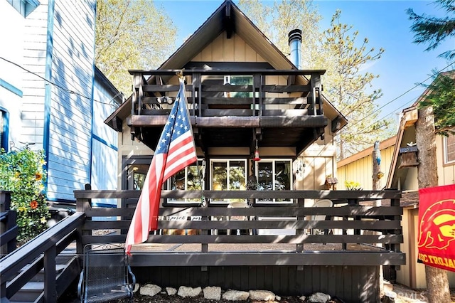 rear view of house featuring a wooden deck