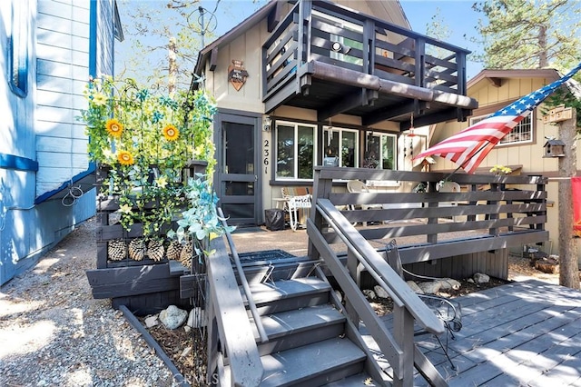 rear view of house featuring a wooden deck and a balcony