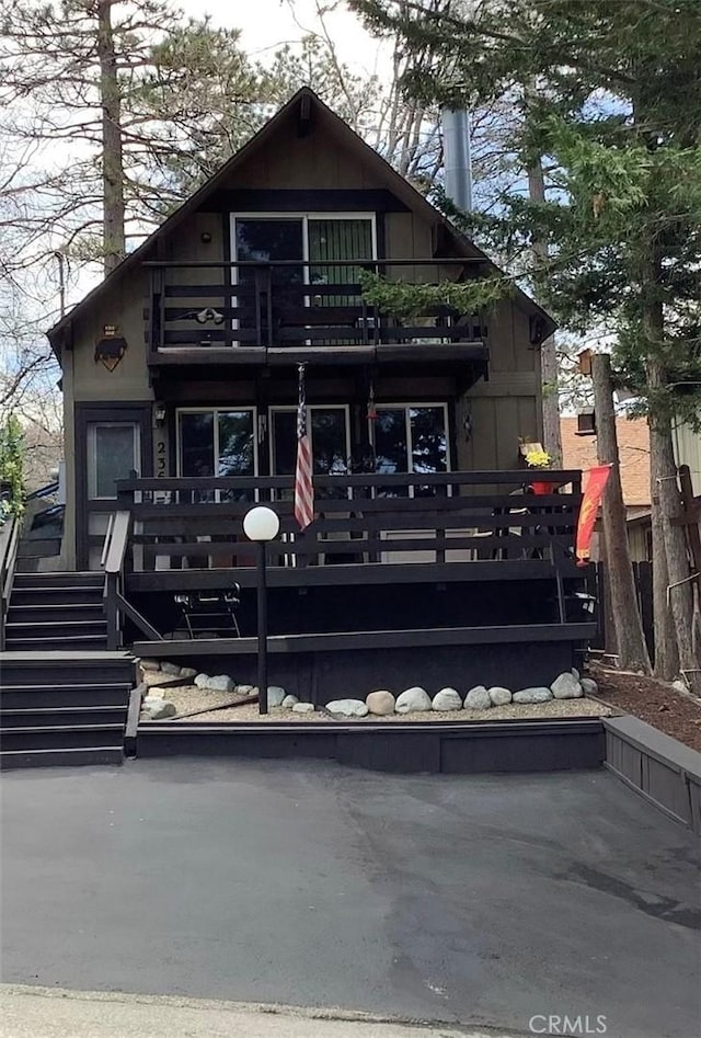 back of house featuring stairway and a balcony