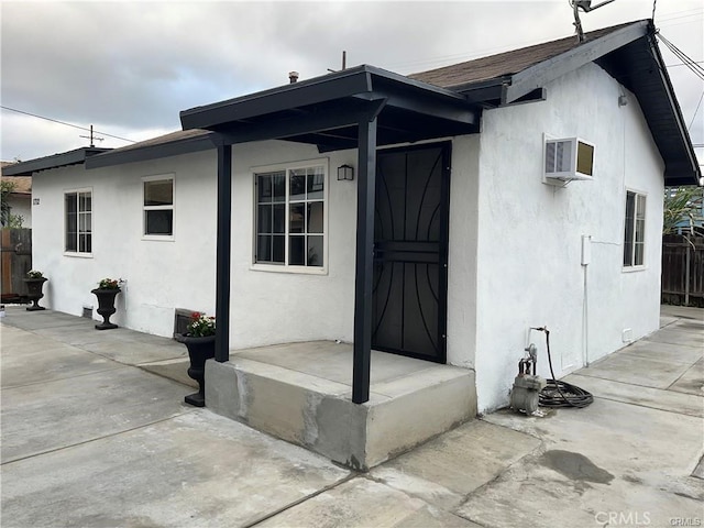 entrance to property featuring a patio and a wall mounted AC