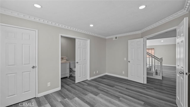 unfurnished bedroom with dark hardwood / wood-style flooring, ensuite bath, and crown molding