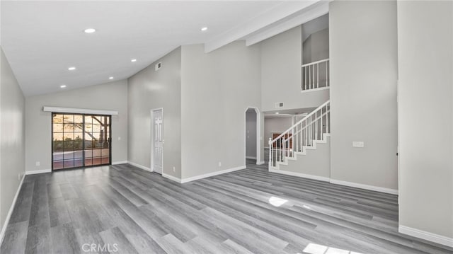 unfurnished living room with hardwood / wood-style flooring and high vaulted ceiling