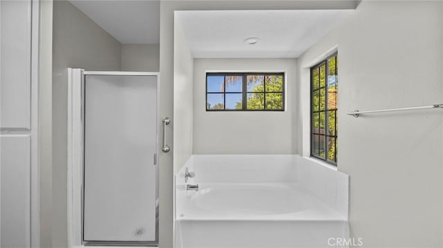 bathroom with a textured ceiling and independent shower and bath