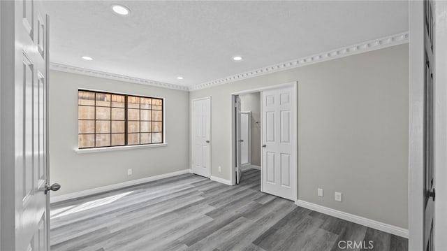 unfurnished bedroom with light hardwood / wood-style floors and a textured ceiling