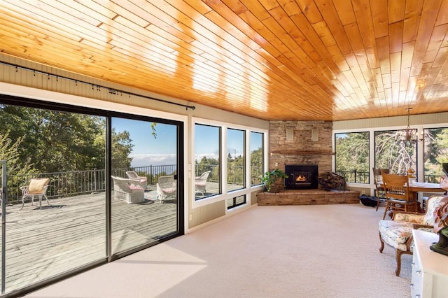 unfurnished sunroom featuring a fireplace and wood ceiling