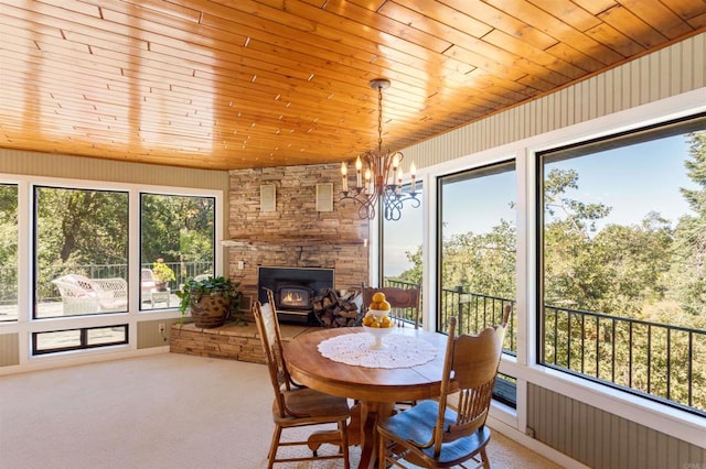 sunroom / solarium featuring a fireplace, a chandelier, and wooden ceiling