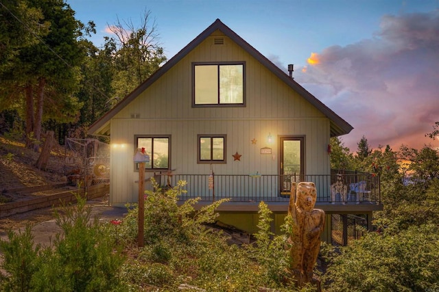 back house at dusk with a wooden deck