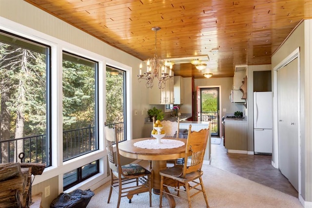 dining area featuring sink, wooden ceiling, and a chandelier