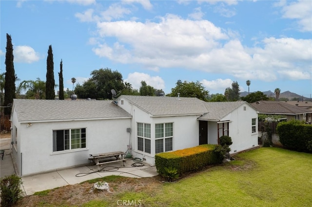 back of property featuring a patio and a lawn