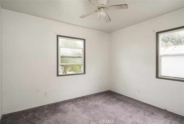 carpeted spare room featuring ceiling fan