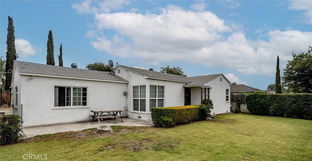 back of house featuring a patio and a yard