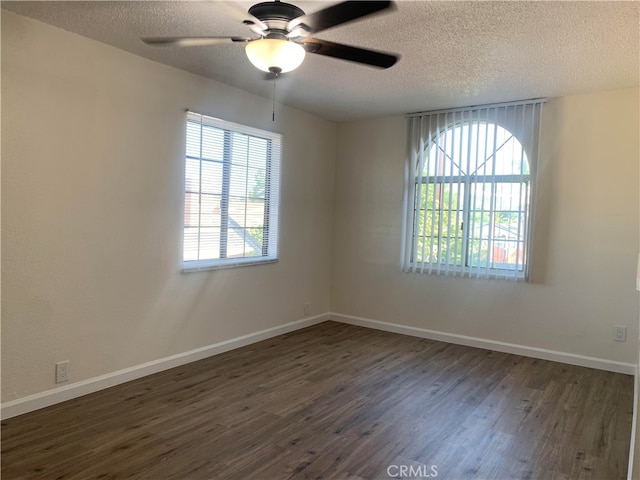 empty room with ceiling fan, a textured ceiling, and dark wood-type flooring