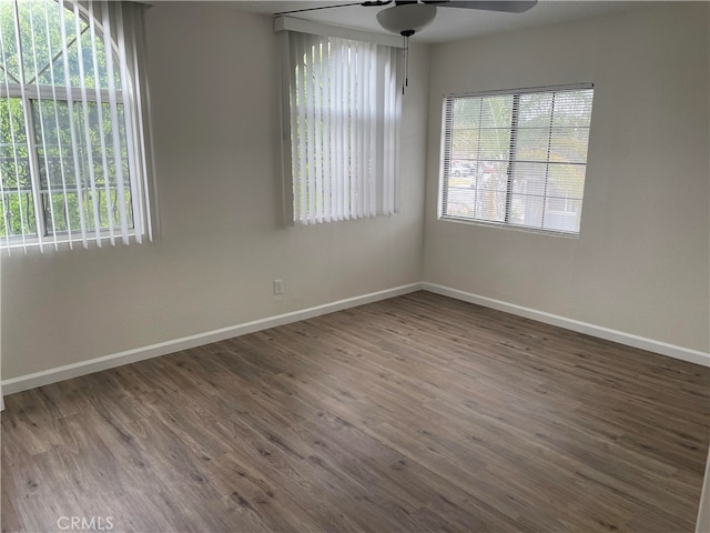 empty room with ceiling fan and dark hardwood / wood-style flooring