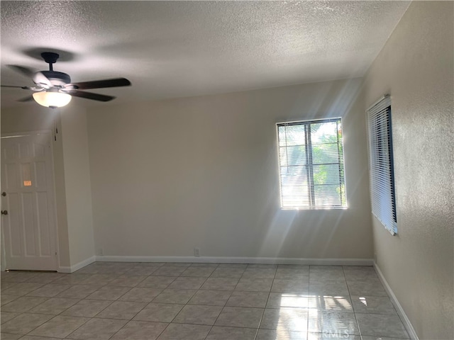 tiled spare room featuring ceiling fan and a textured ceiling