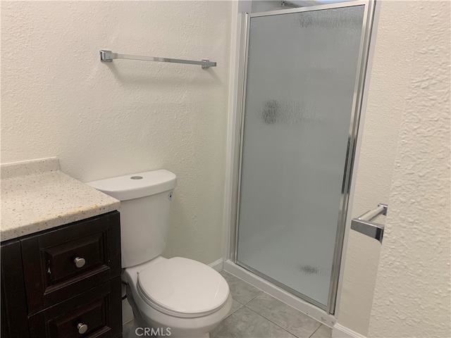 bathroom featuring walk in shower, vanity, toilet, and tile patterned floors