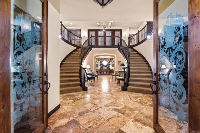 foyer with a towering ceiling and an inviting chandelier