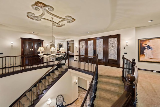 staircase with french doors and carpet floors