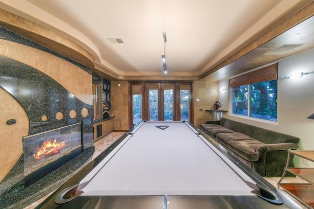 game room with pool table, a fireplace, and french doors