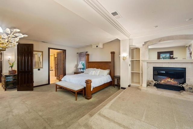 carpeted bedroom with ornamental molding, a tile fireplace, and a notable chandelier