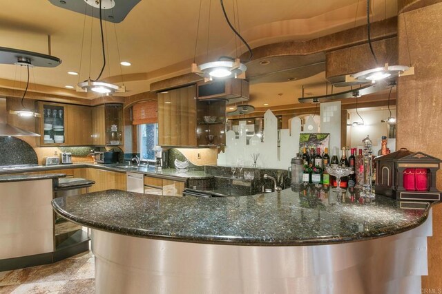 kitchen featuring dishwasher, kitchen peninsula, dark stone counters, and wall chimney range hood