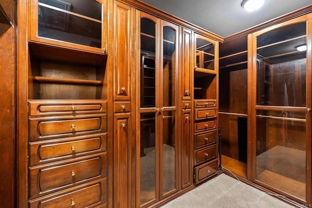 walk in closet featuring light colored carpet